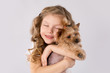 Little girl with white Yorkshire Terrier dog isolated on white background. Kids Pet Friendship